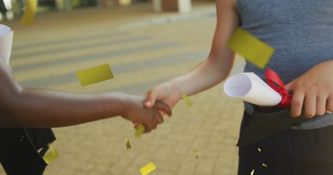 Diverse Boys Celebrating Graduation with Handshake and Diplomas
