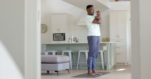 Man Stretching on Yoga Mat in Modern Kitchen Space - Download Free Stock Images Pikwizard.com