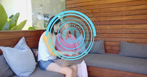 Women Collaborating on Laptop with Futuristic HUD Overlay on Outdoor Wood Bench
