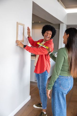 Couple collaborating on home decor with spirit level