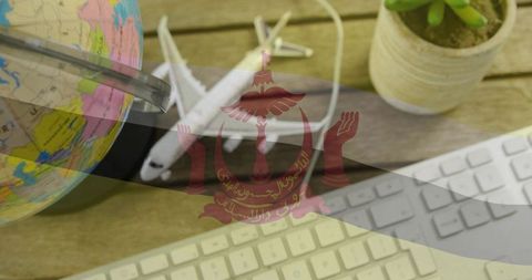Brunei travel planning concept with globe, model plane and minimal desk workspace