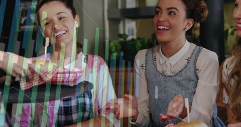 Friends laughing and sharing burger in cozy cafe while data charts overlay