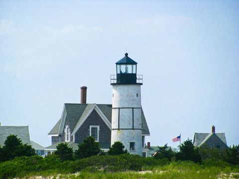 Quaint Lighthouse with Surrounding Beach Houses and Garden