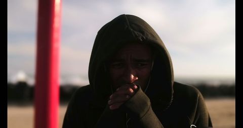 Pensive Young African American Athlete on Sunny Beach