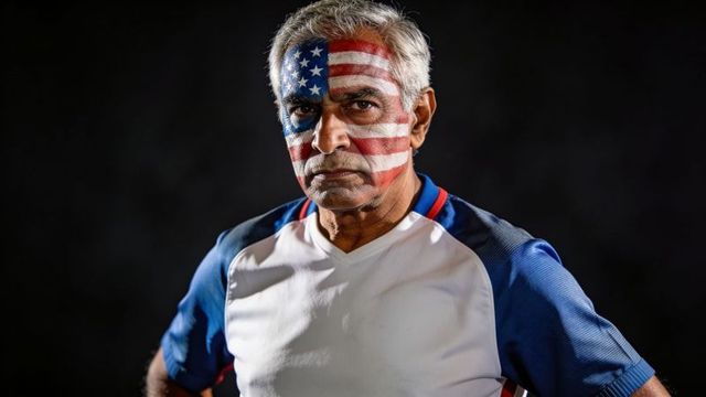 Senior man wearing american flag face paint displaying patriotic pride and determination