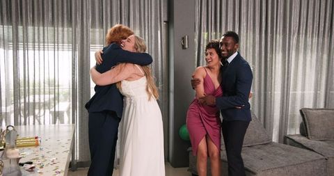 Joyful Wedding Celebration with Friends in Living Room Setting