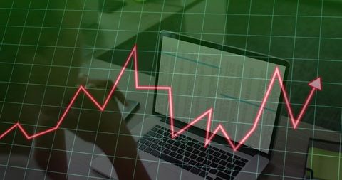 Businesswoman analyzing data on laptop with trend line overlay