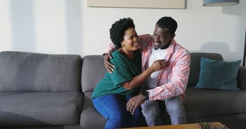 Joyful couple engaging in surprise proposal at home