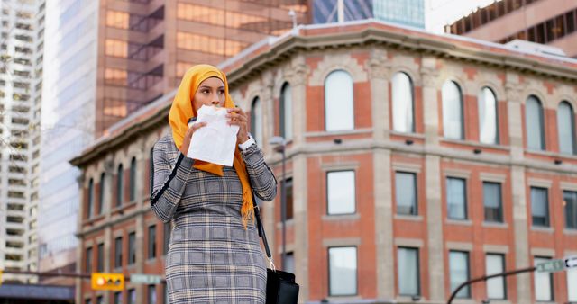 Businesswoman Wearing Hijab Eating Snack in City Center - Download Free Stock Images Pikwizard.com