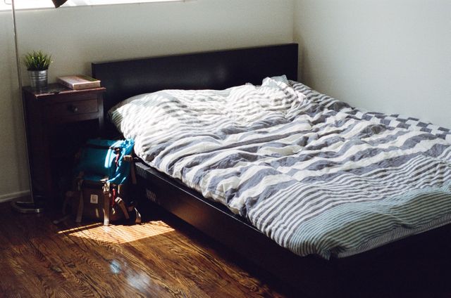 Cozy bedroom with sunlight on bed and wooden floor - Download Free Stock Photos Pikwizard.com