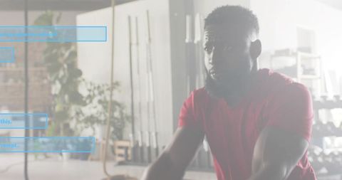 Man training through intense cardio session with gripping handles in bright functional gym