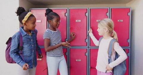 Schoolgirls Conversing by Lockers in Education Hallway