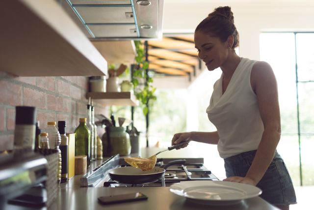 Side view of beautiful woman preparing food in kitchen at comfortable home