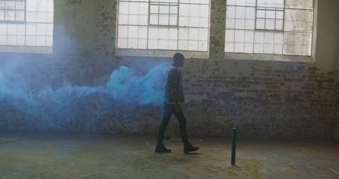 Man Walking by Blue Smoke in Historic Industrial Room - Download Free Stock Images Pikwizard.com