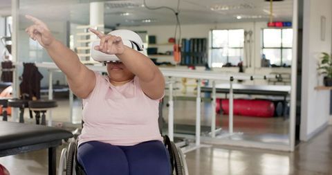 Woman in wheelchair using vr for rehabilitation exercise