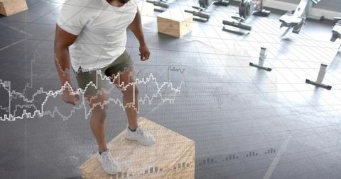 Male athlete performing box jump with performance metrics overlay in modern gym