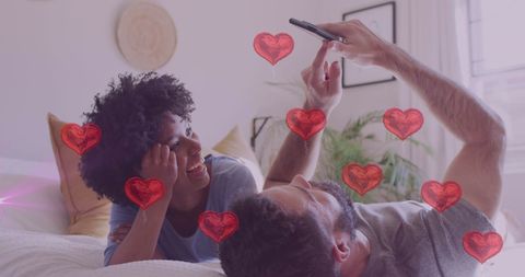 Couple Laughing with Smartphone Surrounded by Digital Hearts