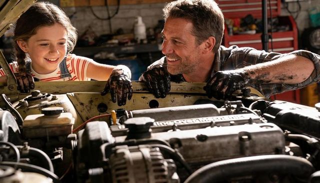Father and daughter fixing car engine in garage teaching hands-on mechanic skills