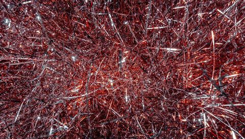 Red metallic tinsel macro sparkling texture with foil strands and glitter shine