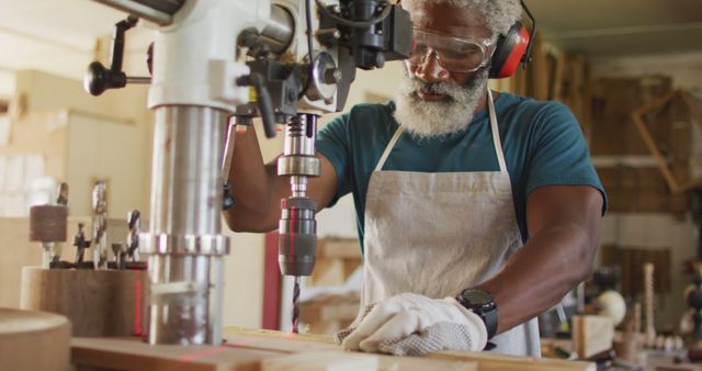 African american male carpenter drilling wood with a laser drill in a carpentry shop. carpentry, craftsmanship and handwork concept