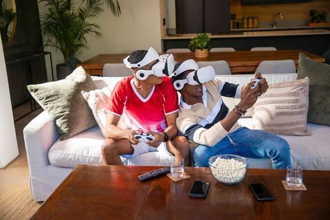 Two Friends Enjoying Virtual Reality Gaming Experience at Home