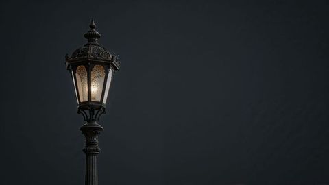 Vintage street lamp with intricate filigree against dark night sky