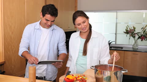 Couple Enjoying Interactive Cooking with Tablet in Modern Kitchen
