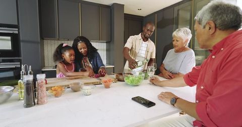 Multiracial Multigenerational Family Preparing Salad at Modern Kitchen Island Gathering