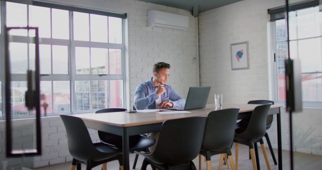 Professional Seated at Modern Workspace with Large Window - Download Free Stock Images Pikwizard.com