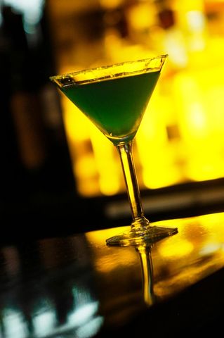 Elegant Green Cocktail in Martini Glass at Dimly Lit Bar