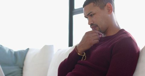 Man in Deep Thought at Home Relaxing on Modern Sofa