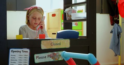 Young schoolgirl pretends executive role in play shop