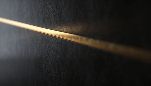 Minimalist dark textured wall featuring glowing gold inlay running diagonally