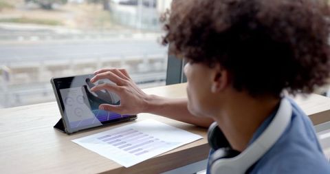 Business professional analyzing data on tablet in modern workspace