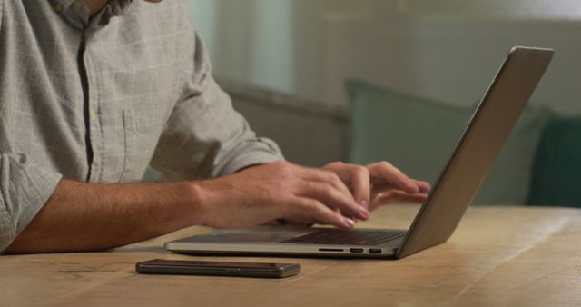 Person Typing on Laptop with Smartphone on Wooden Desk - Download Free Stock Images Pikwizard.com