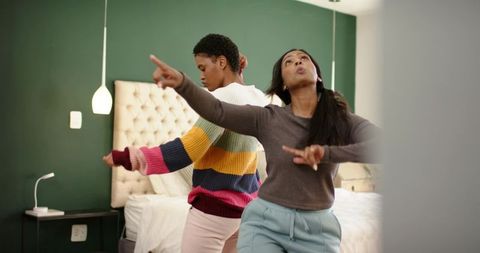 Friends Dancing in Cozy Bedroom with Vibrant Decor