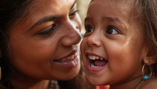 Laughing mother and toddler sharing joyful laughter close-up portrait warm family bond