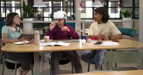 Students Using VR Headset While Collaborating in Coworking Lounge for Immersive Learning