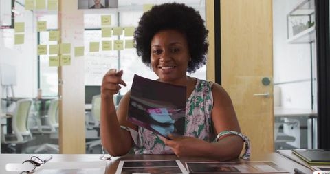 Creative Professional Analyzing Photographs at Collaborative Workspace