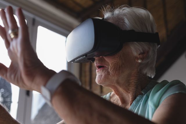 Senior woman using virtual reality headset - Download Free Stock Photos Pikwizard.com