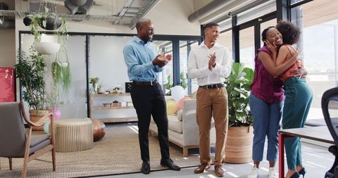 Colleagues celebrating success in bright modern office setting