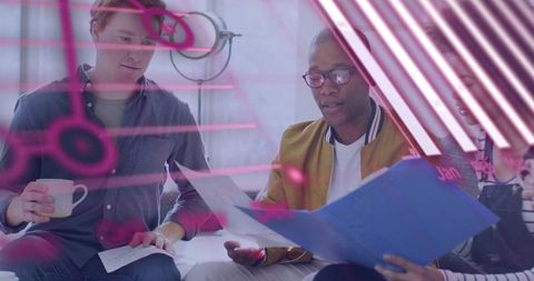 Team Reviewing Project Documents under Pink Neon Reflection in Modern Workspace