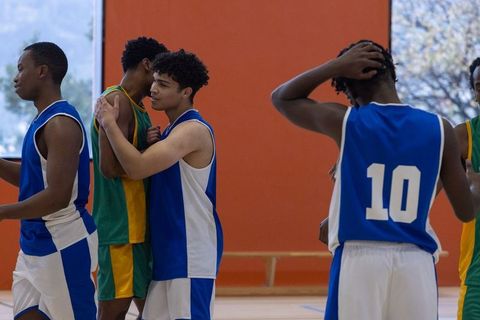Diverse basketball players embracing sportsmanship after game