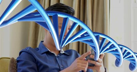 Asian man exploring personal DNA data on smartphone in sunlit living room with blue helix