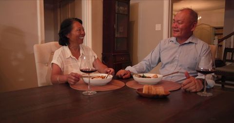 Senior Couple Enjoying Dinner and Wine Together at Home