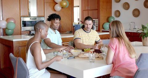 Friends Gathering Around Table Enjoying Meal Together