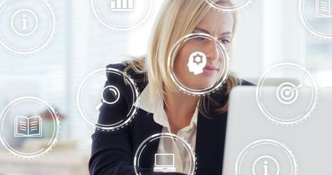 Middle-aged businesswoman analyzing data on laptop with digital interface icons for analytics