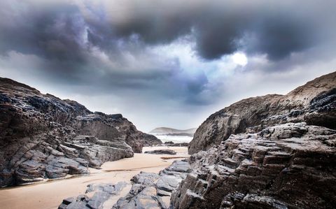 Dramatic rocky beach coastline with overcast sky