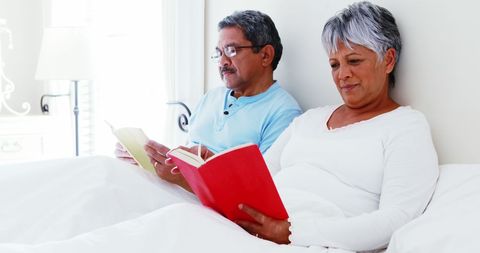 Senior Couple Relaxing in Bed with Books at Sunlit Home - Download Free Stock Images Pikwizard.com