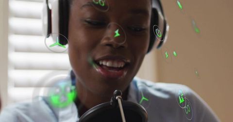 Smiling woman podcasting with headset and pop-filter surrounded by green ar icons